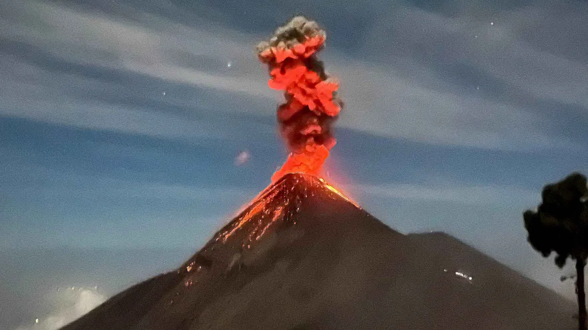 Red lava bursting from Volcan de Fuego at dusk viewed across the valley on a 2-day Acatenango volcano tour from Antigua, Guatemala